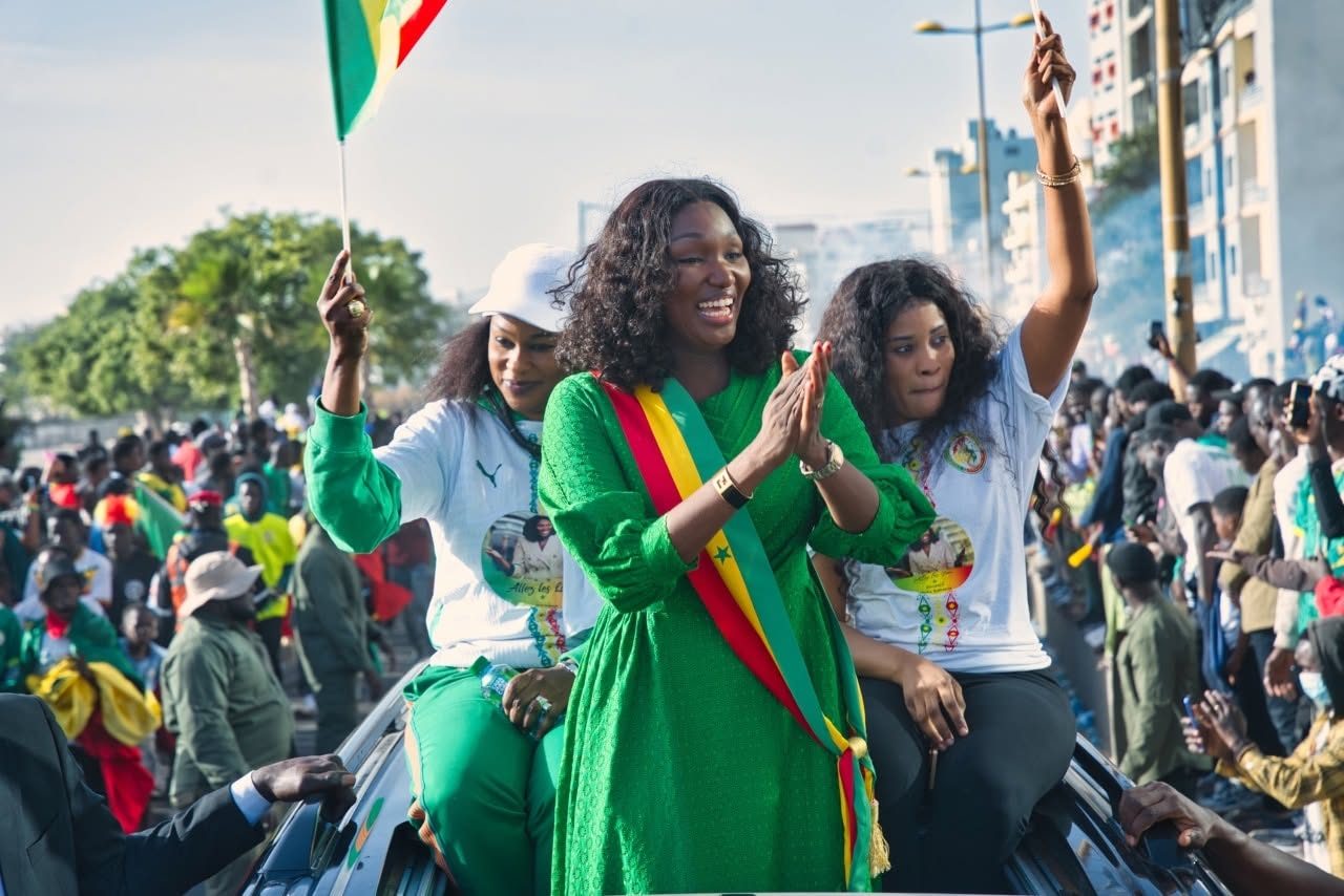 Caravane nationale — la Présidente saluant la foule, drapeau du Sénégal à la main